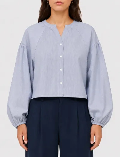 شومیز آستین رگلان رنگ آبی روی مدل با شلوار پارچه ای سورمه ای رنگ
